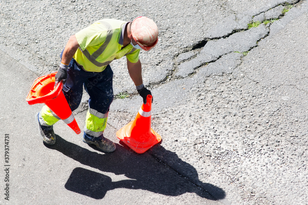construction worker with reflective vest and road traffic cones in highway site for maintenance construction worker with reflective vest and road traffic cones in highway site for maintenance
