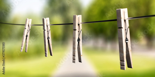 Clothespins on clothes line against nature background. 3d illustration