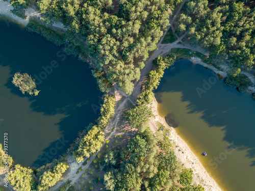 Two lakes in the park among conifers. Aerial drone view.