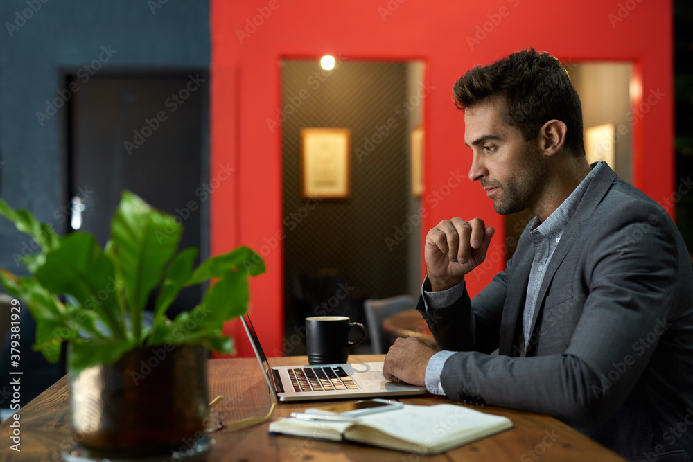 Focused businessman working on a laptop at his office desk