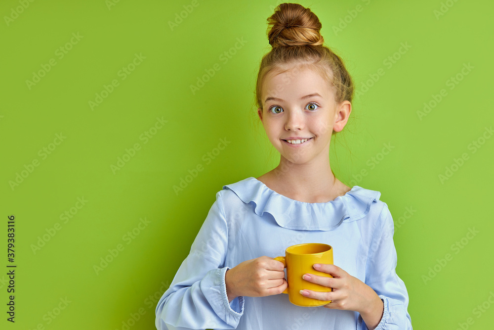 beautiful caucasian child girl drinking hot tea or coffee in the morning, enjoy happy beginning of day, isolated on green background beautiful caucasian child girl drinking hot tea or coffee in the morning, enjoy happy beginning of day, isolated on green background