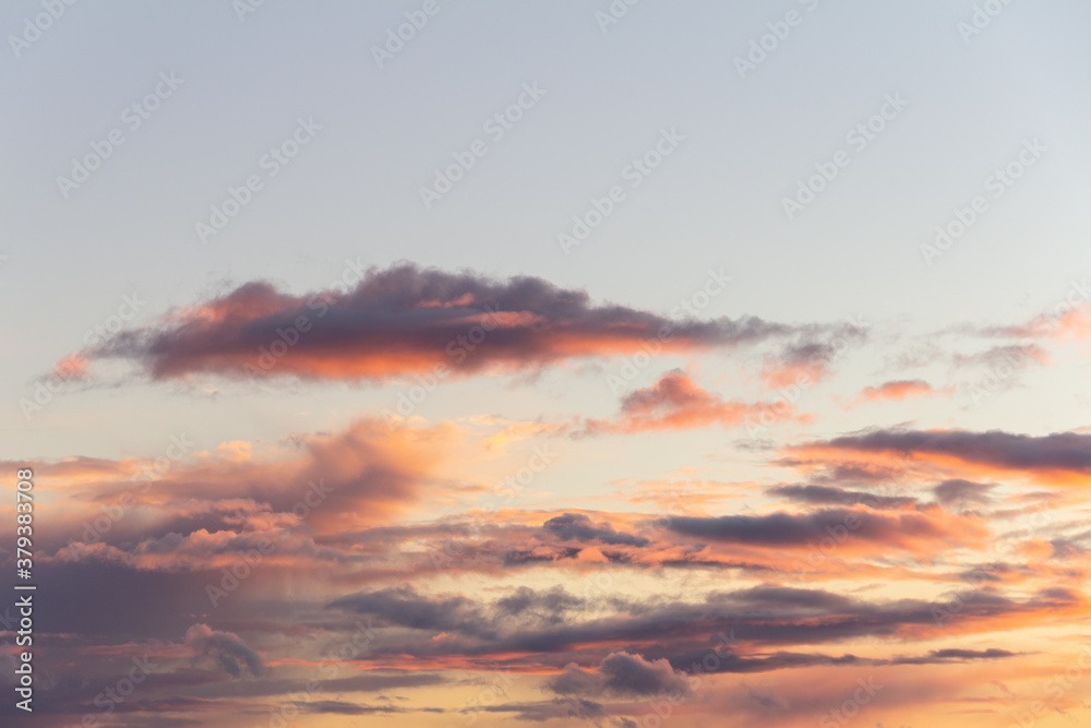Evening sky with rain clouds in orange-pink sunset light