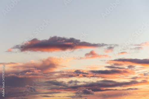 Evening sky with rain clouds in orange-pink sunset light