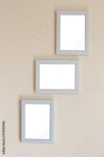 Collage of three white frames on a beige wall