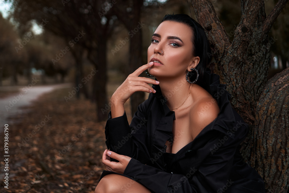 Beautiful girl walking outdoors in autumn wearing in black coat and black shoes Beautiful girl walking outdoors in autumn wearing in black coat and black shoes