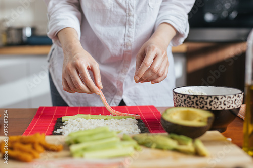 Female chef preparing sushi in the kitchen