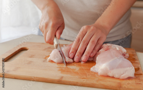 Slicing chicken fillet. Cooking fried chicken in a pan.