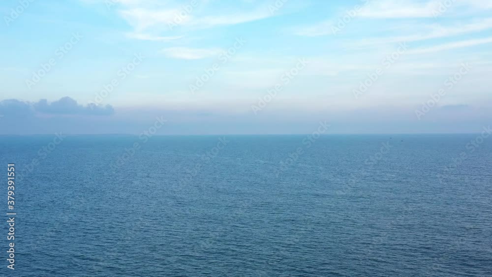 Drone rises higher and higher above blue sea. Aerial view to ocean and clouds on horizon. Beautiful top view to sea Drone rises higher and higher above blue sea. Aerial view to ocean and clouds on horizon. Beautiful top view to sea