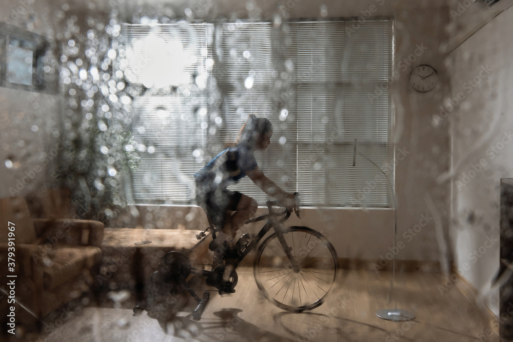 Asian woman cyclist. She is exercising in the home.By cycling on the trainer and play online bike games.During the rainy season Asian woman cyclist. She is exercising in the home.By cycling on the trainer and play online bike games.During the rainy season