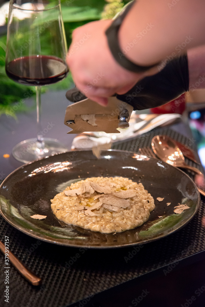 Chef sliced black truffle on delicious risotto