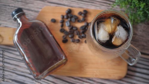 Ice cold brew coffee on wooden table. 