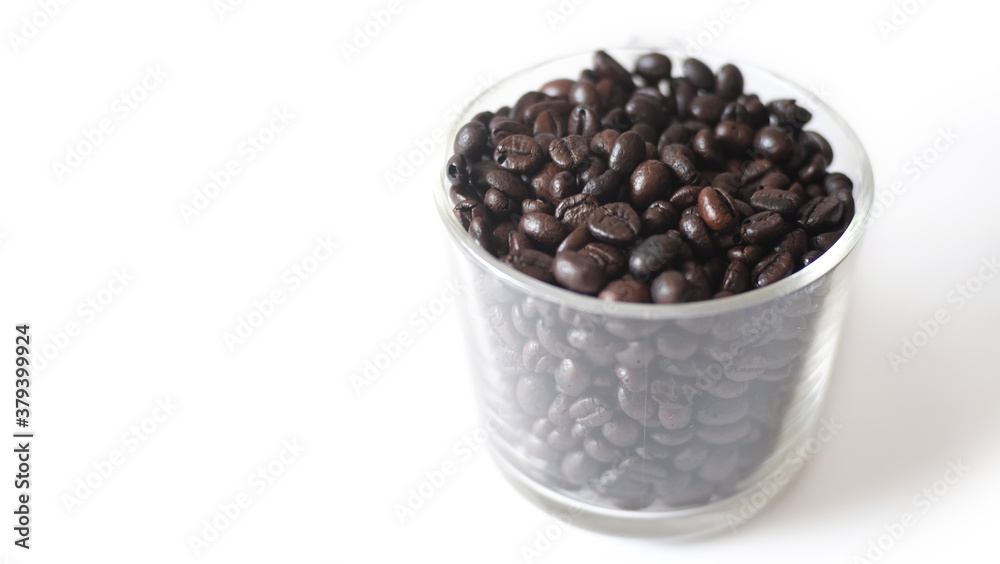 Grains of coffee in a glass on a white background for a fragrant drink. Grains of coffee in a glass on a white background for a fragrant drink.