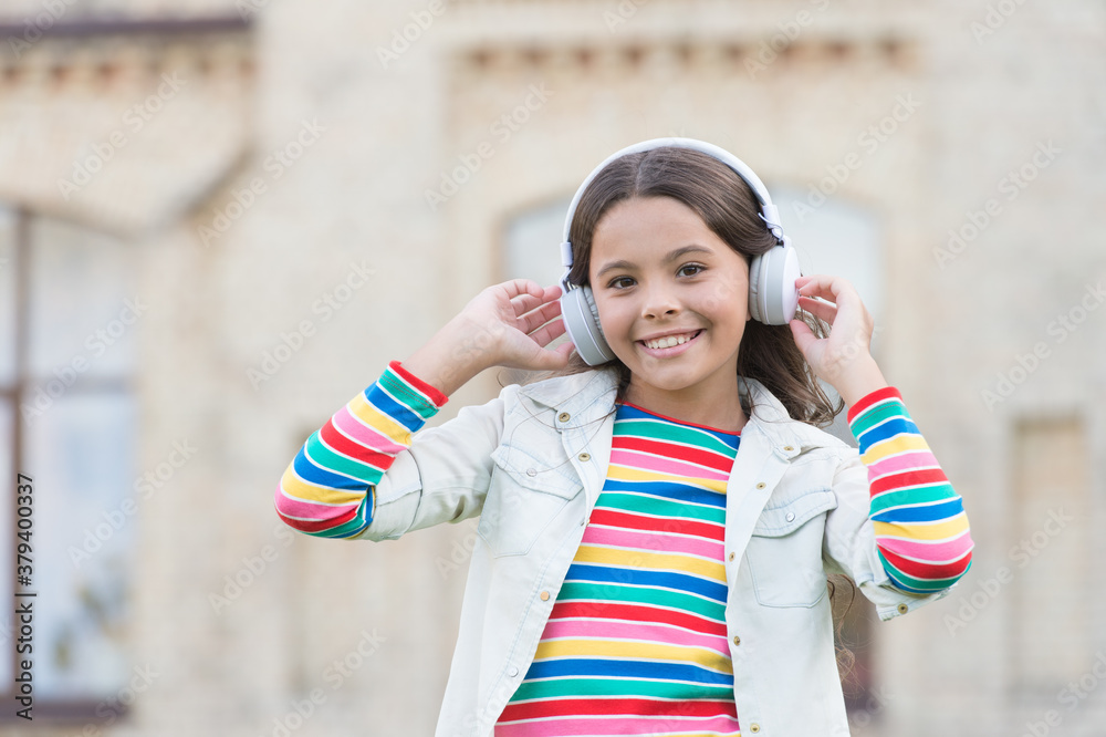 Φωτογραφία Happy energetic girl listening music modern headphones, childrens day concept