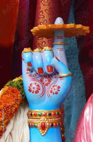 Hand of Hindu god Vishnu statue with weapon chakra