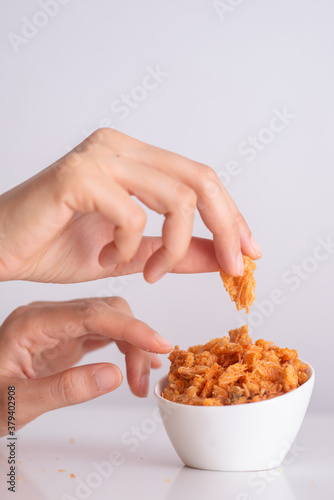 girl pick crunchy golden salty snack in white cup