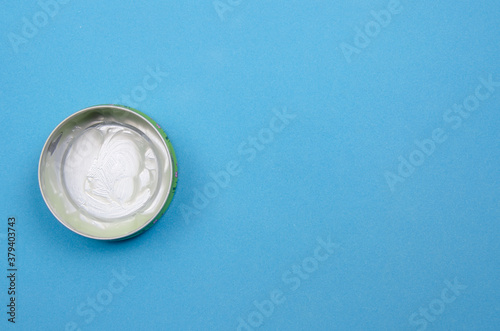 empty can of cream on a blue background with copy space, top view.