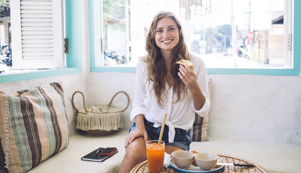 Content woman with sandwich having meal in comfortable place Content woman with sandwich having meal in comfortable place