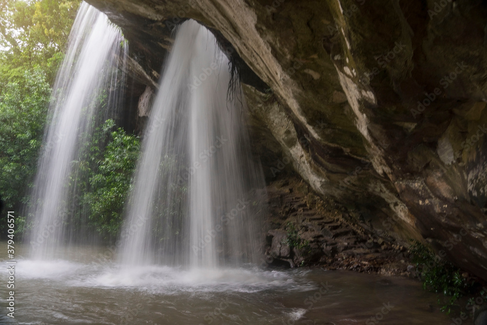 Fototapeta premium Sang Chan (Moonbean) Waterfall or Hole Waterfall in Khong Chaim, Ubon Ratchathani, Thailand. It's the tourists attractions with waterfall flows through a hole cut naturally into the overhanging rock.