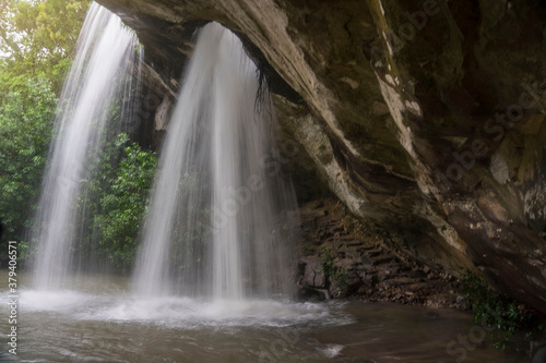 Fototapeta Naklejka Na Ścianę i Meble -  Sang Chan (Moonbean) Waterfall or Hole Waterfall in Khong Chaim, Ubon Ratchathani, Thailand. It's the tourists attractions with waterfall flows through a hole cut naturally into the overhanging rock.