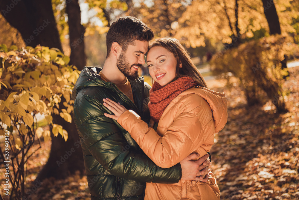 Photo of positive charming affectionate couple guy hug his girlfriend in autumn september outdoors park