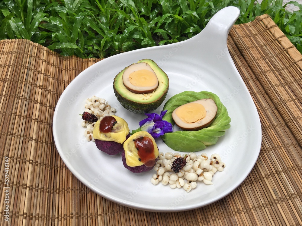 Avocado with brown boiled egg and baked purple potatoes mixed chess and millet