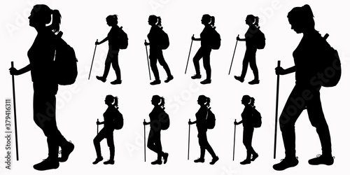 A tourist with a backpack on her back and a walking stick in her hand. The girl walks. Woman on the move. Hiking. Side view, profile. Black female silhouettes isolated on white background.