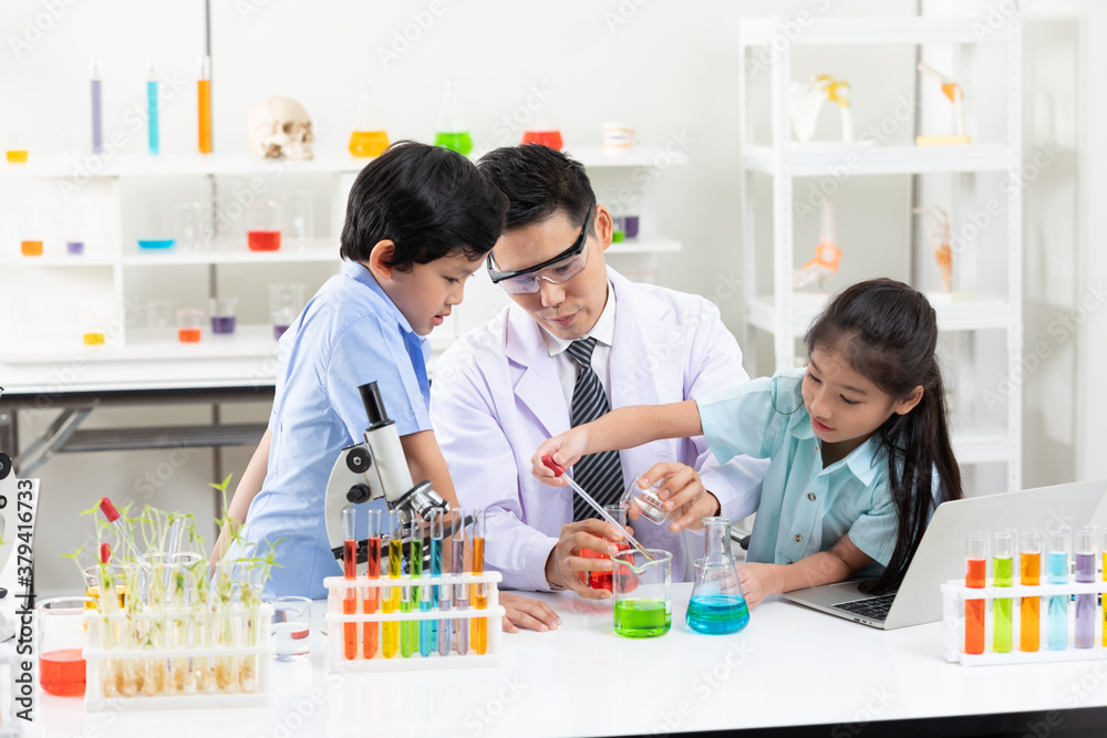 science teacher doing or testing a chemical experiment with child students in laboratory classroom science teacher doing or testing a chemical experiment with child students in laboratory classroom