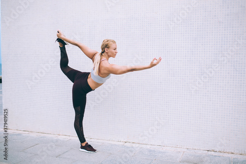 Strong sportswoman practicing yoga exercise outside