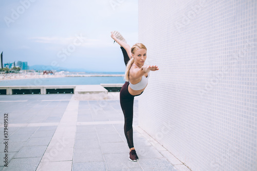 Sporty woman doing yoga on seafront