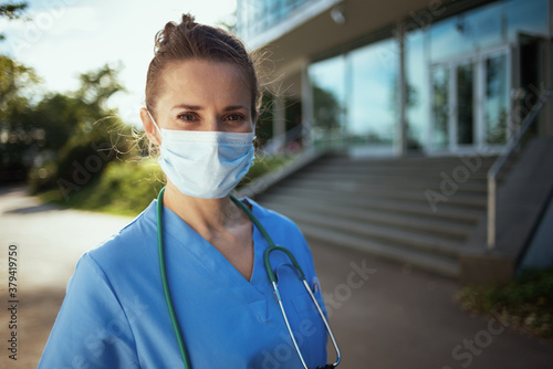 modern physician woman in uniform outside near clinic