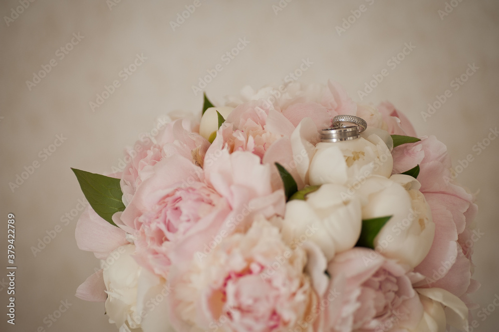 Two wedding rings on a delicate wedding bouquet