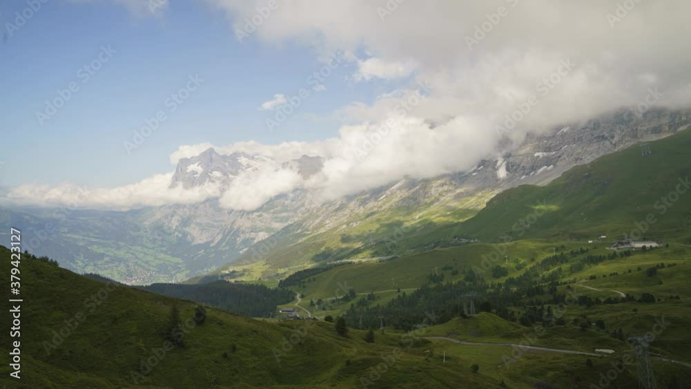 Breathtaking View Of Clouds Moving Above The Kleine Scheidegg Mountain Pass In Summer In Switzerland. Grindelwald Village And V-Cableway Gondola With A View Of Eiger And The Wetterhorn. - timelapse Breathtaking View Of Clouds Moving Above The Kleine Scheidegg Mountain Pass In Summer In Switzerland. Grindelwald Village And V-Cableway Gondola With A View Of Eiger And The Wetterhorn. - timelapse