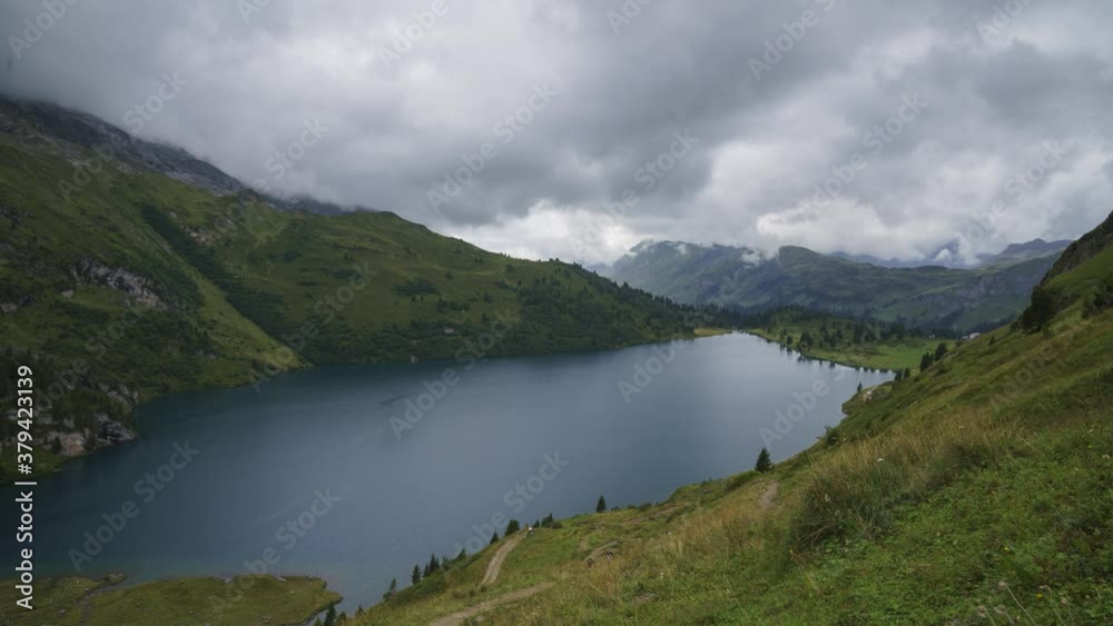 White Clouds Rolling Over The Beautiful Engstlensee Lake By The Lush Mountain On Summer In Innertkirchen, Bernese Oberland, Switzerland. - timelapse White Clouds Rolling Over The Beautiful Engstlensee Lake By The Lush Mountain On Summer In Innertkirchen, Bernese Oberland, Switzerland. - timelapse