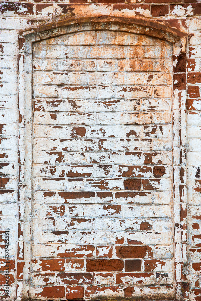 Naklejka premium old red brick wall with remnants of plaster and paint, texture, background