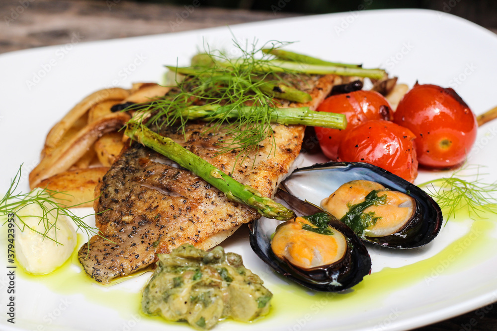 Pan-fried seabass fillet, New Zealand mussels, grilled vegetables, and salsa verde sauce. Pan-fried seabass fillet, New Zealand mussels, grilled vegetables, and salsa verde sauce.