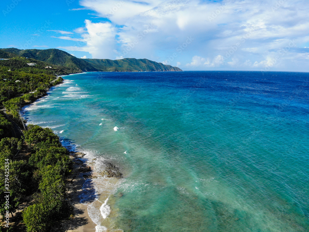 Drone shot looking down the beach of a Caribbean island