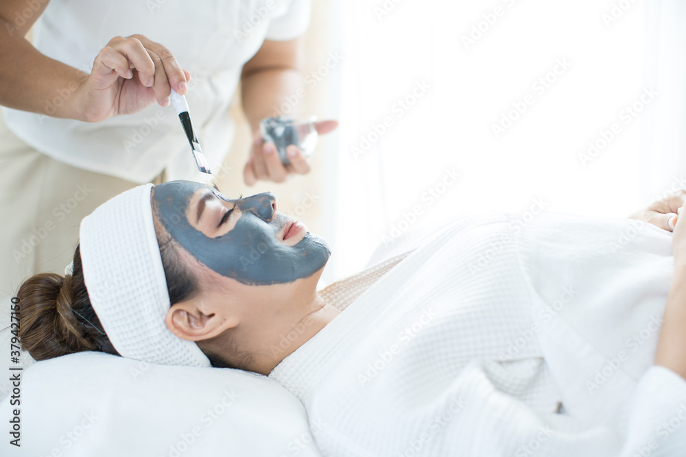 Face Skin Care. An Asian woman is masking her face in a spa salon. Woman with cosmetic spa facial mask. Thailand.