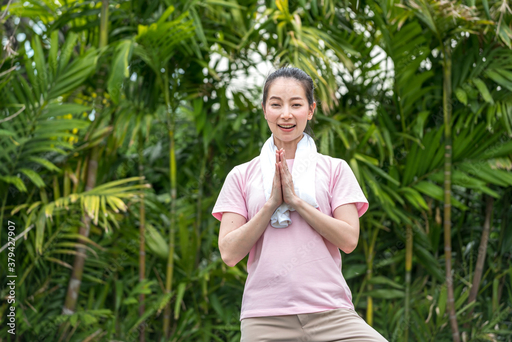 Asian Beauty and healthy woman exercise and doing meditation of yoga on exercise mat in the outdoor park - fitness, sport, yoga concept. Asian Beauty and healthy woman exercise and doing meditation of yoga on exercise mat in the outdoor park - fitness, sport, yoga concept.