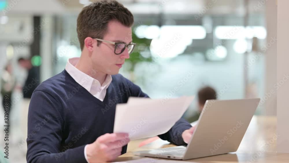 Young Businessman Working on Laptop and Documents Young Businessman Working on Laptop and Documents
