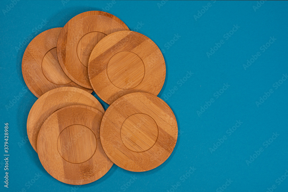 Bamboo saucers arranged in various order, with space to insert letters of text
