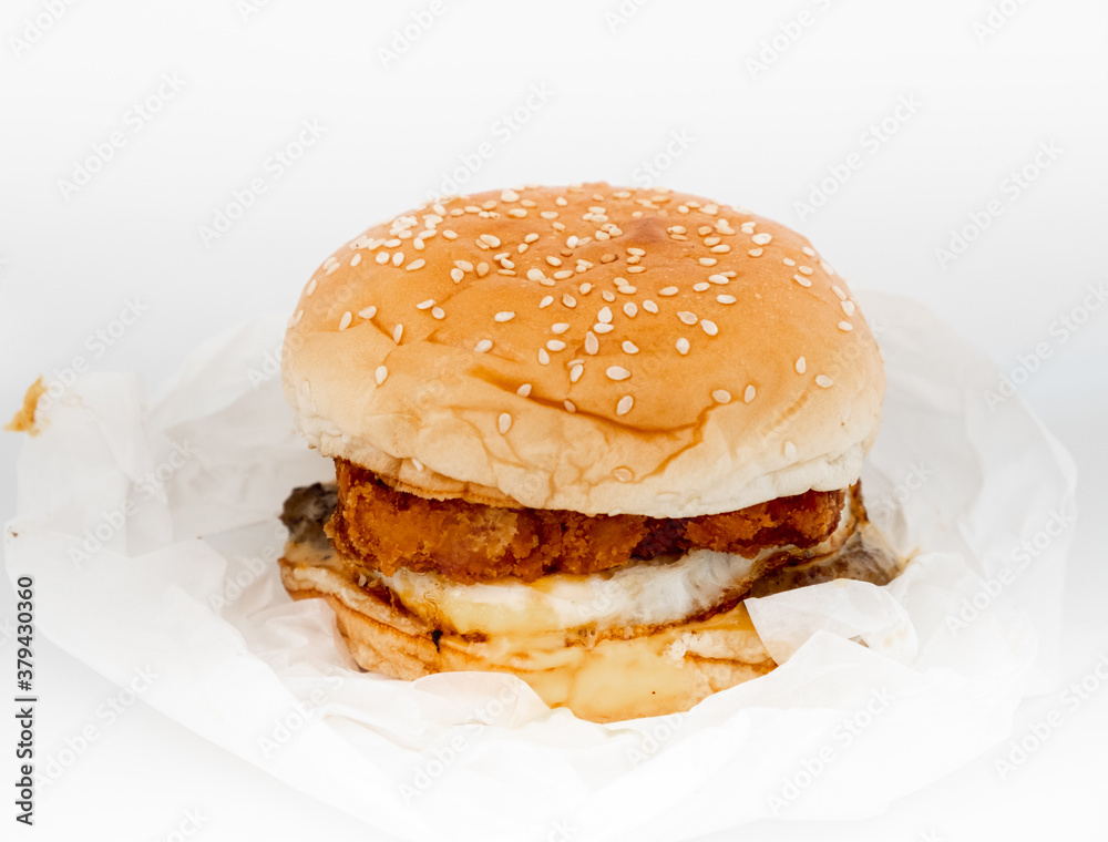 Closeup of big beef hamburger in food wrapping foil Closeup of big beef hamburger in food wrapping foil
