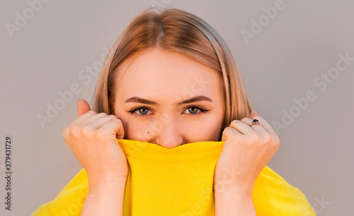Beautiful natural young shy woman with smiling eyes wearing yellow sweetshot
