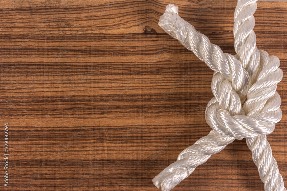 Knot with rope on wooden background with space for writing. Concept of inner and strengthening Knot with rope on wooden background with space for writing. Concept of inner and strengthening
