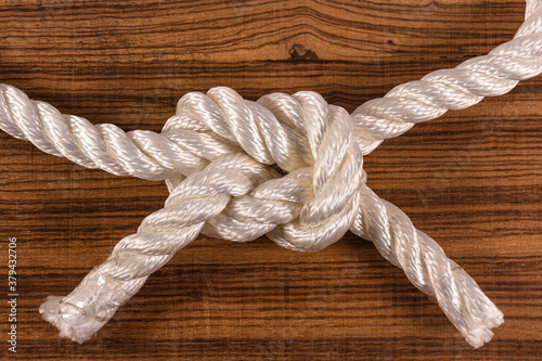 Knot with rope on wooden background with space for writing. Concept of inner and strengthening