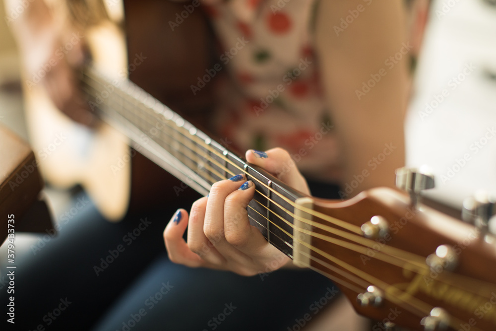 Close up of young girl hands playing acoustic guitar