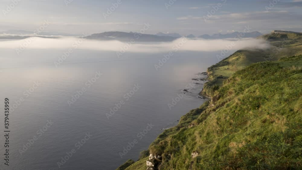 View of low clouds forming and rolling over sea and coastline during early morning on the Isle of Skye, Scotland. 4k time lapse video View of low clouds forming and rolling over sea and coastline during early morning on the Isle of Skye, Scotland. 4k time lapse video