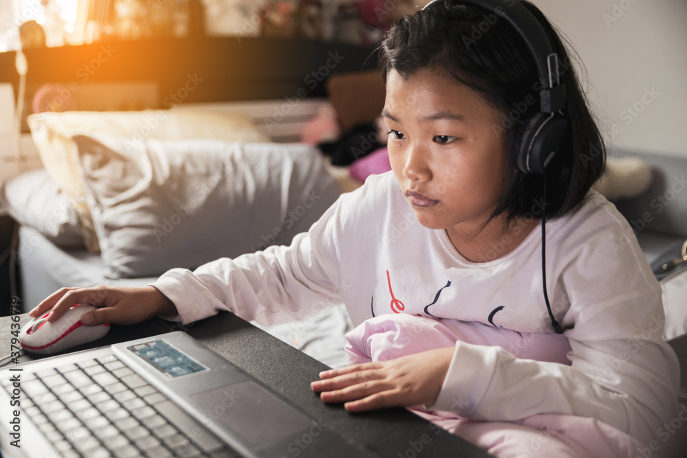 Asian children using laptop to learning and doing homework at home. Happy Thai Students study online for study to the exam. Education concept. Asian children using laptop to learning and doing homework at home. Happy Thai Students study online for study to the exam. Education concept.