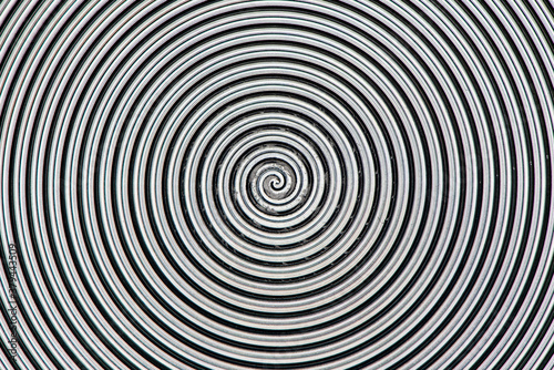 Aluminum metal surface with spiral pattern texture closeup photo background.