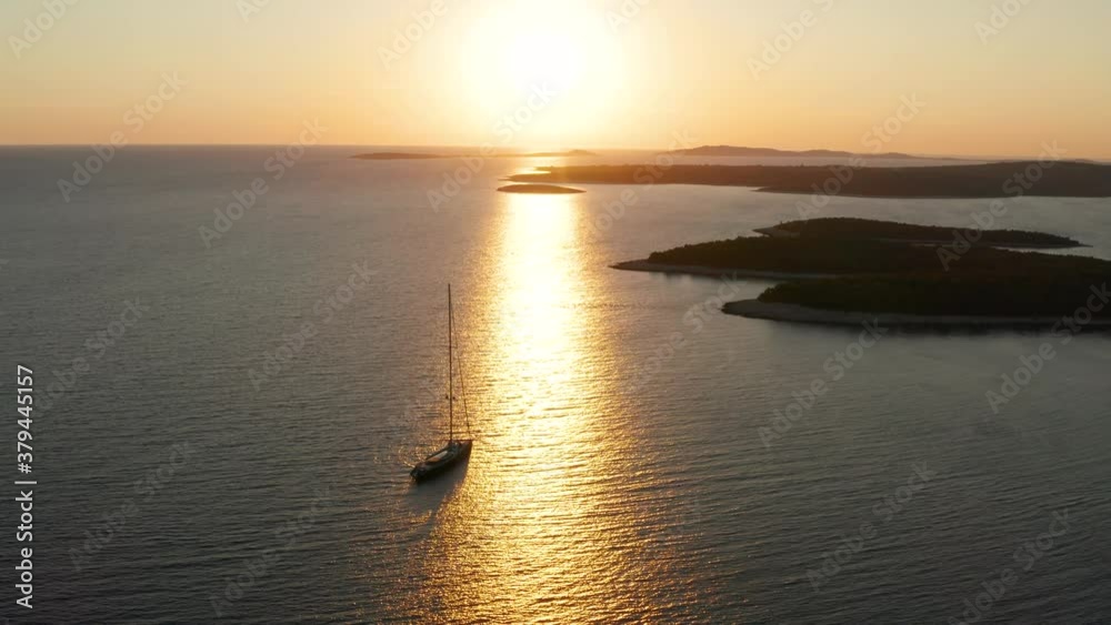 Golden Hour Reflection At The Calm Water Of Adriatic Sea By The Island Of Losinj With Boat Sailing In Kvarner Bay, Croatia. - Wide Shot Golden Hour Reflection At The Calm Water Of Adriatic Sea By The Island Of Losinj With Boat Sailing In Kvarner Bay, Croatia. - Wide Shot