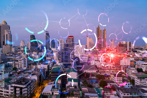 Hologram of abstract technology glowing icons  panoramic cityscape of Bangkok at sunset  Asia. The concept of worlds technological changes. Double exposure.